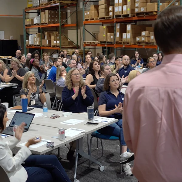 PAR employees gather in the PAR warehouse for a team celebration