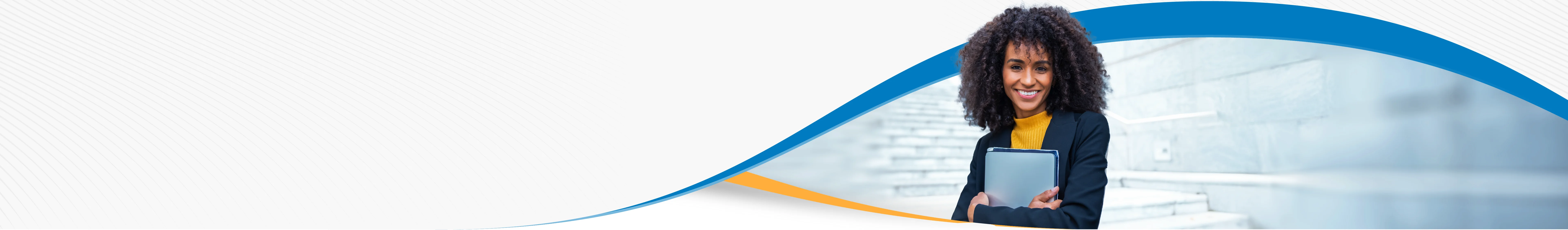 A woman with an orange shirt and navy blue blazer stands holding her ipad to her chest